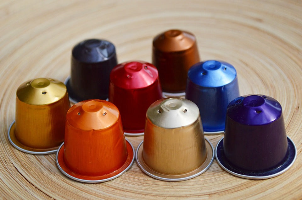 Kleurrijke koffiecapsules gerangschikt op een houten oppervlak